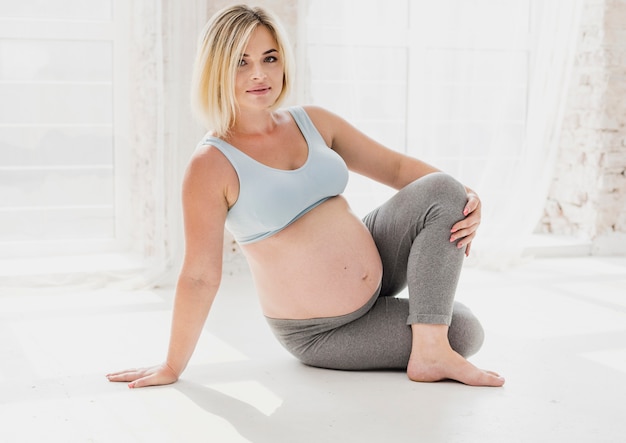 Front view pretty pregnant woman doing yoga