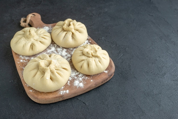 front view raw dumplings on cutting board dark background meat food dinner restaurant horizontal