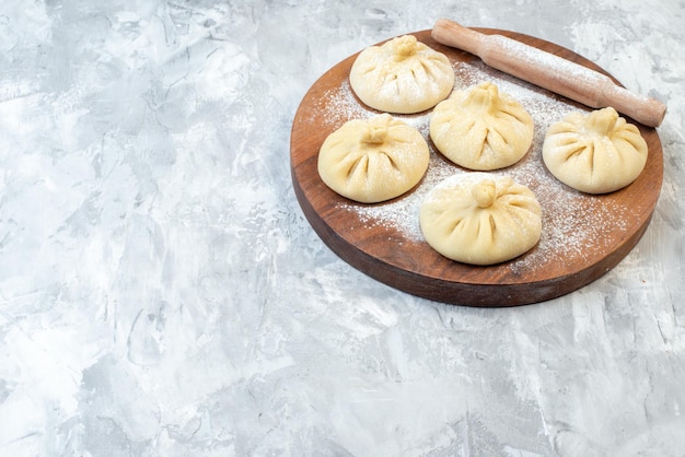 Front view raw little dumplings on light background pie color bake cake dough salad meat food