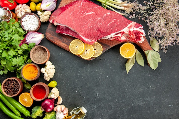 front view raw meat slice with vegetables greens and seasonings on a dark background ripe health diet food meal color salad