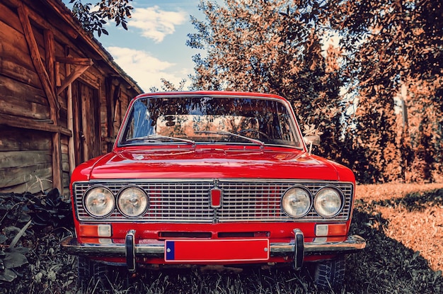 Front view of a red vintage Lada car in the countryside  Old red Soviet car