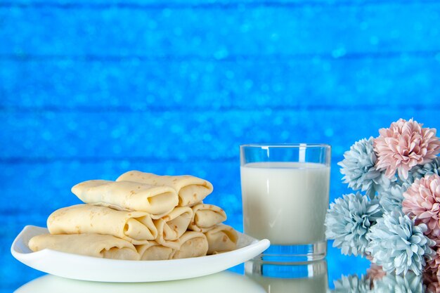 front view rolled sweet pancakes with glass of milk on blue background meal cake breakfast color food sugar flower