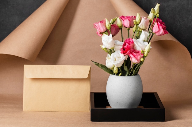 Photo front view roses in vase composition with envelope