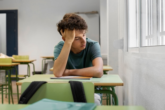 Foto adolescente triste di vista frontale a scuola