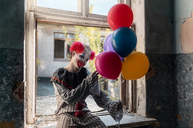 Photo front view scary clown in abandoned building