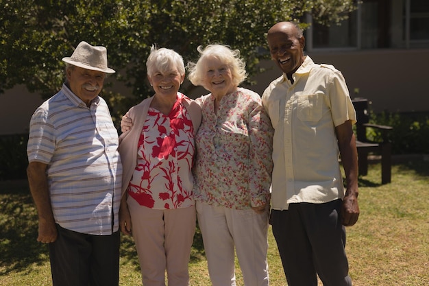 Photo front view of senior friends looking at camera in garden