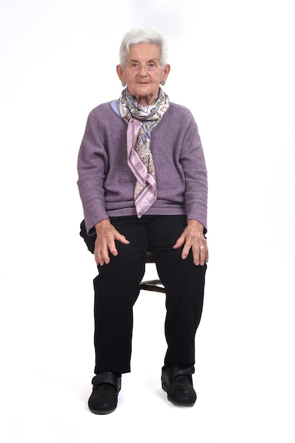 Front view of senior woman sitting on chair on whte