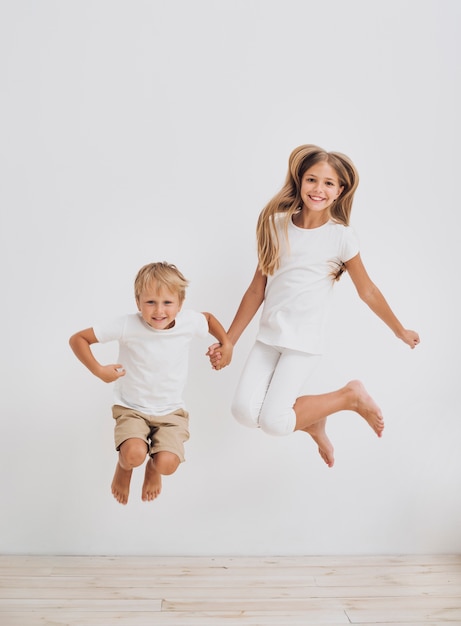 Front view siblings jumping together 