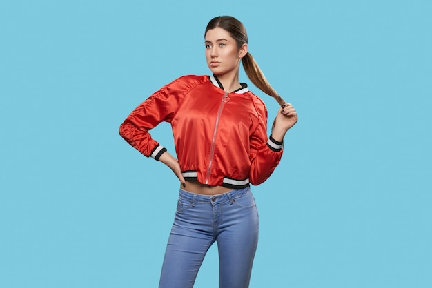 Foto vista frontale di giovane modello esile in giacca sportiva e jeans