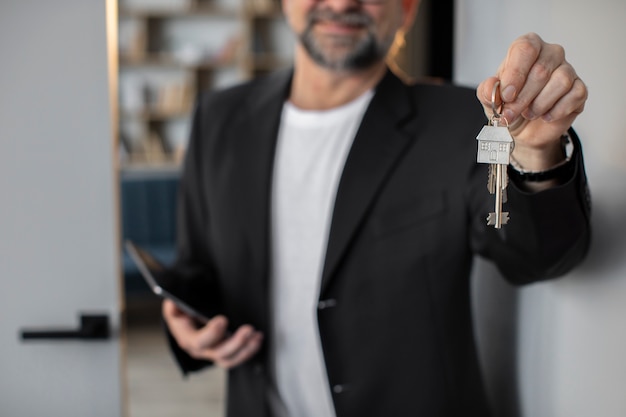 Photo front view smiley host holding keys