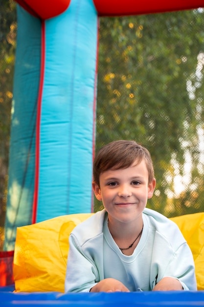 Photo front view smiley kid in bounce house