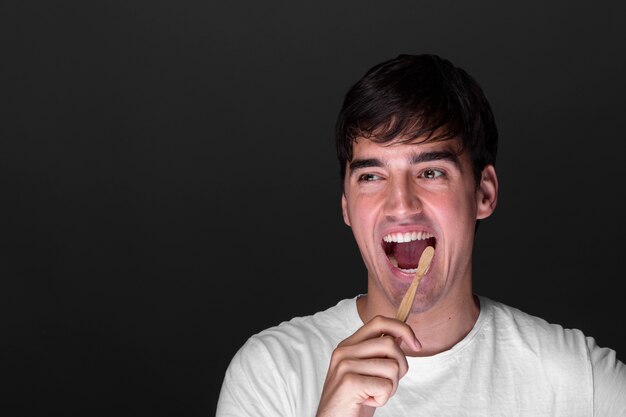 Foto uomo di smiley vista frontale lavarsi i denti