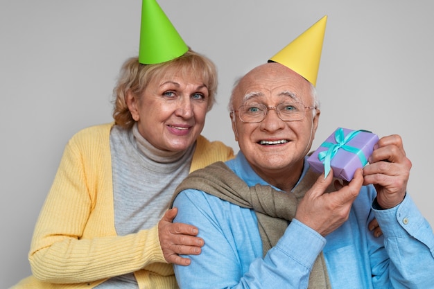 Photo front view smiley old man holding gift