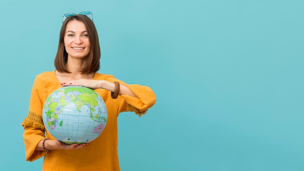 Vista frontale del globo della terra della tenuta della donna di smiley con lo spazio della copia