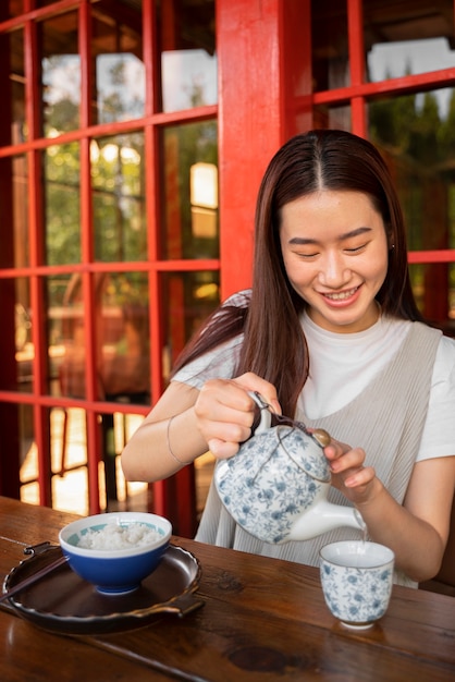 Photo front view smiley woman pouring water