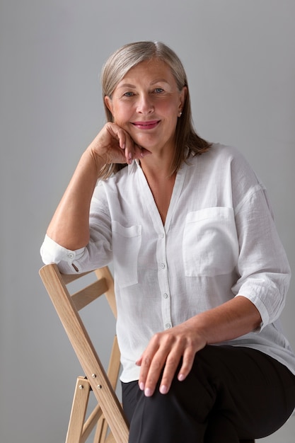 Photo front view smiley woman sitting on chair