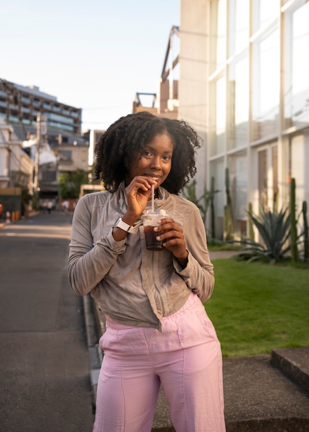 Photo front view smiley woman with iced coffee