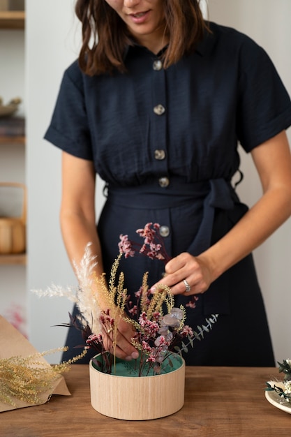 Front view smiley woman working with flowers