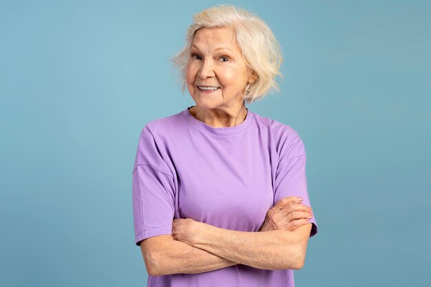 Photo front view of smiling elderly caucasian woman with crossed arms