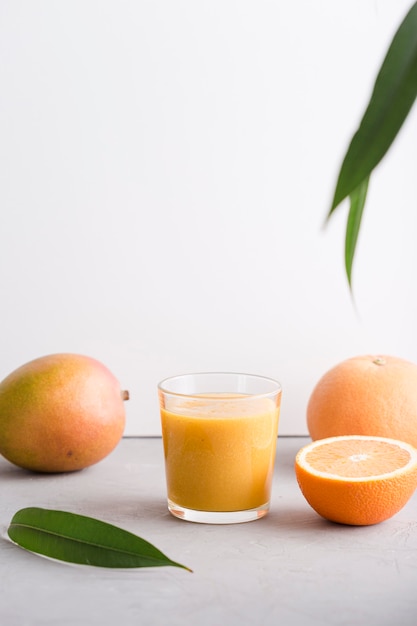 Photo front view smoothie glass with orange and mango