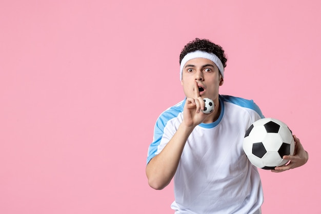 Front view soccer player in sport clothes with ball