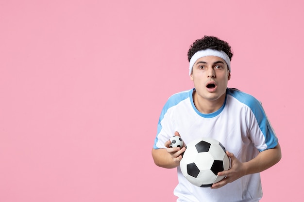 Front view soccer player in sport clothes with ball