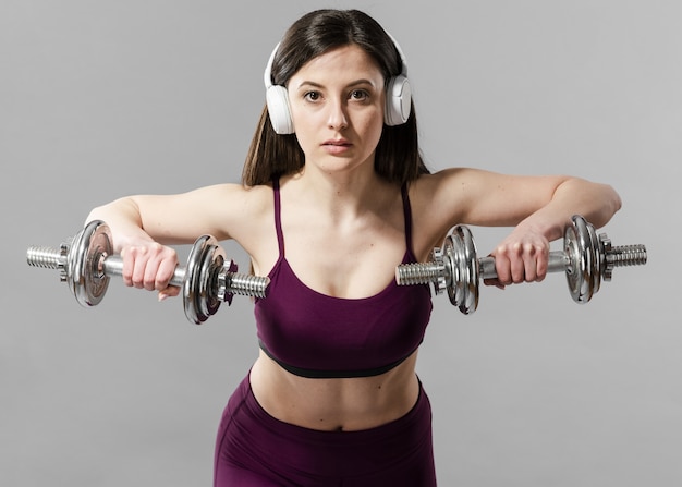 Foto vista frontale della donna sportiva con manubri