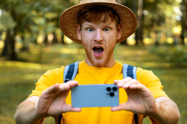 Uomo sorpreso vista frontale che prende selfie