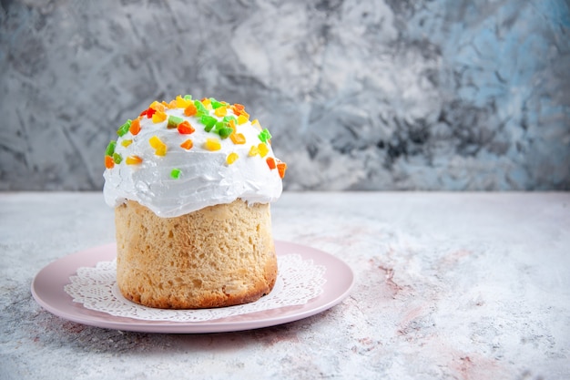 正面図白いクリームとドライフルーツの白い表面のプレートの内側のおいしいイースターケーキ春のデザート甘いパイイースターカラフル