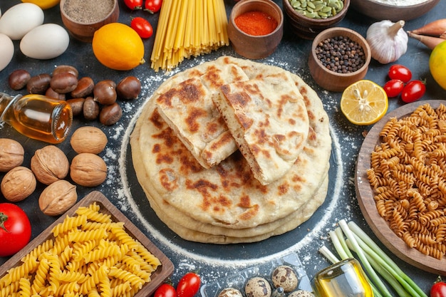 Вид спереди вкусные оладьи с различными ингредиентами, приправами и макаронами на темном фоне, цвет булочки, еда, орехи, блюдо, хлеб