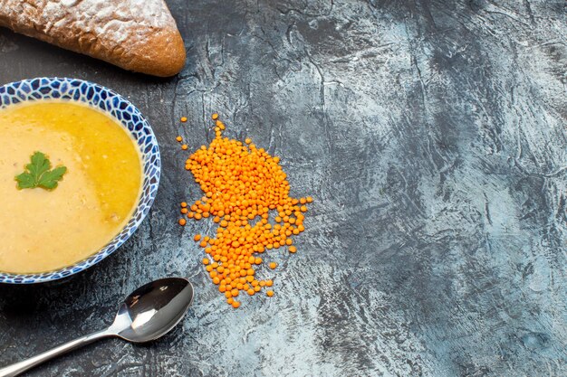 Vista frontale gustosa zuppa di lenticchie all'interno della piastra con pane su sfondo grigio cucina foto pasto cena pepe piatto colore vegetale