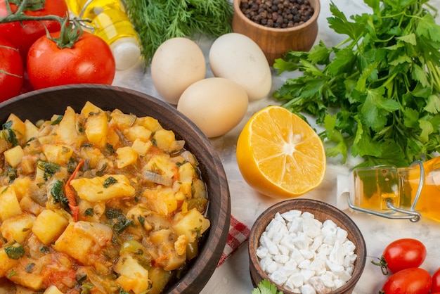 Front view of tasty meal with potatoes on red stripped towel fallen oil bottle green bundles eggs pepper