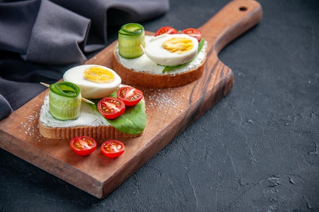 front view tasty sandwiches with tomatoes cucumbers and eggs on cutting board dark background toast meal food bread snack burger sandwich lunch