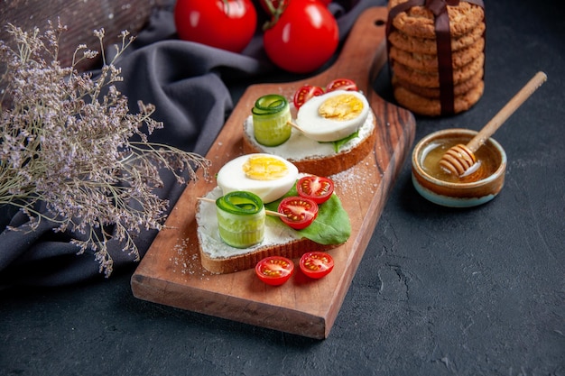 front view tasty sandwiches with tomatoes and eggs on cutting board dark background lunch toast snack burger sandwich food bread meal