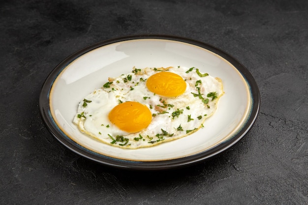Foto vista frontale gustose uova strapazzate all'interno della piastra su sfondo scuro omelette cibo colazione mattina pranzo pane pasto da tè