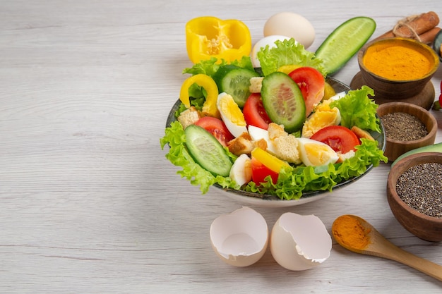 Front view tasty vegetable salad with seasonings on white background meal food breakfast ripe colors