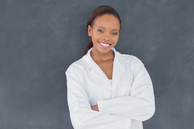 Front view of a teacher next to a blackboard