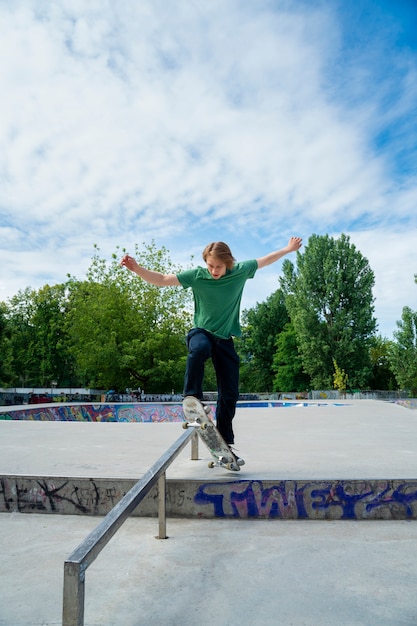 Front view teen with skateboard outdoors