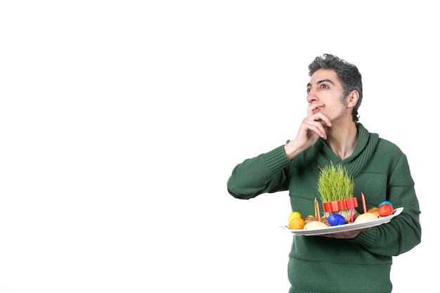 front view thinking young man holding traditional novruz xoncha on white background colours performer ethnicity horizontal ethnic concept spring