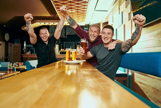 Photo front view of three male fans watching football