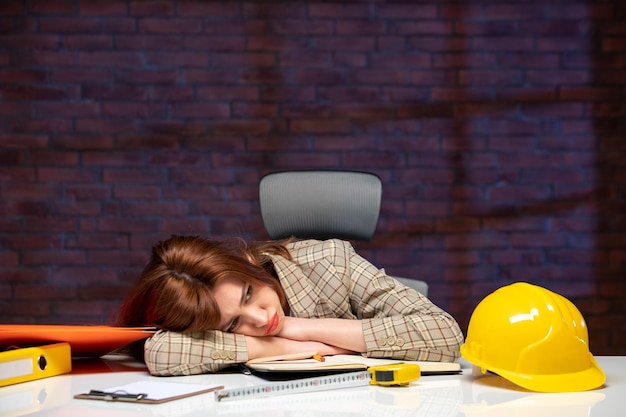 Photo front view tired female engineer sitting behind her working place in construction site job agenda business corporate contractor property success plan builder