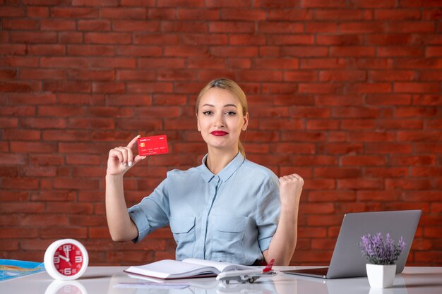 front view of travel agent holding red credit card assistant map global manager professional working job agency money