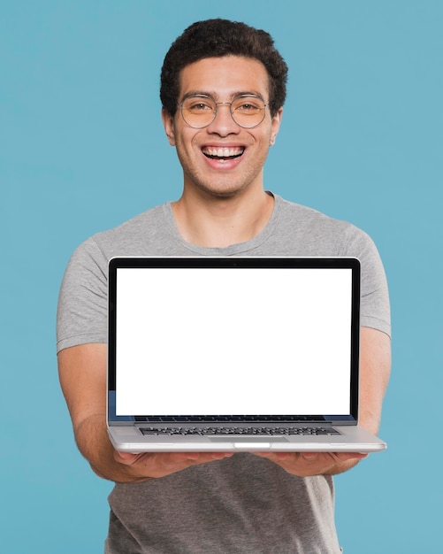 Foto studente universitario di vista frontale che tiene il computer portatile