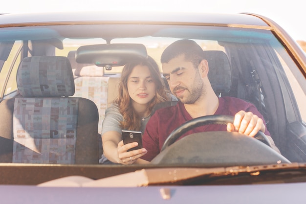 Front view of unshaven male driver sits at wheel and drives his automobile