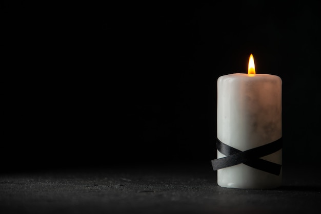 Front view of white candle on black