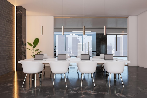 Front view on white chairs near big white meeting table with
modern laptops on dark marble floor in stylish conference room with
white and brick walls and city view from big window 3d
rendering