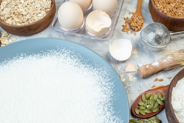 Vista frontale farina bianca con mele banane uova cereali crudi e semi su sfondo bianco torta di pasta di semi torta di latte colore mais