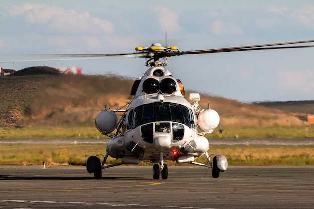 Front view of the white transport helicopter on the airport apron