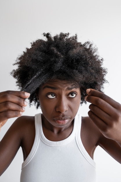 Foto donna di vista frontale che sistema i capelli