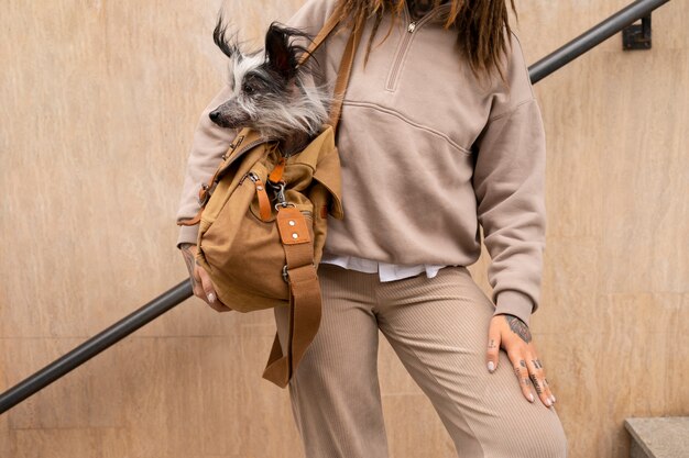 Photo front view woman carrying dog in bag